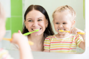 tips for kids healthy teeth - parent and child brushing teeth together