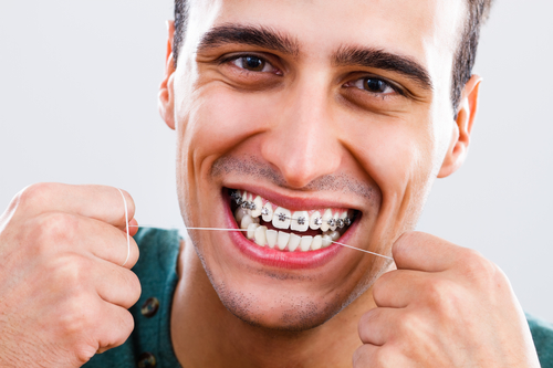 man flossing with braces