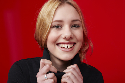 Young woman smiling against red background