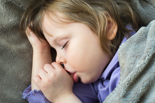 young girl sleeping and sucking her thumb