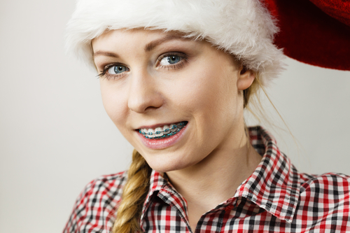 girl wearing santa hat, smiling with braces