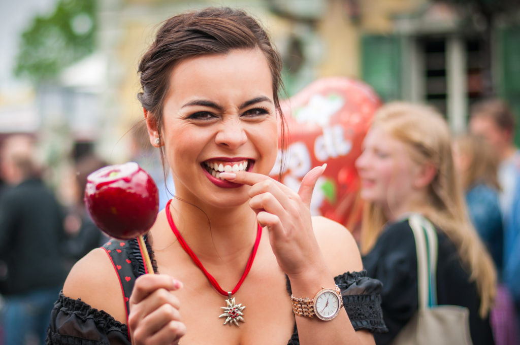 Woman with a nice smile eating a candy apple.