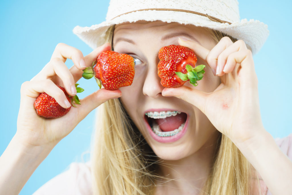 Girl with braces enjoying fresh berries as a summer treat.