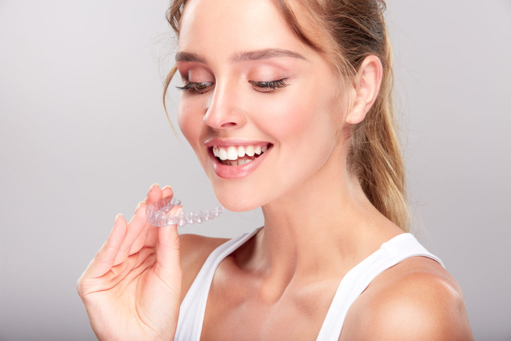 Happy woman with SureSmile clear aligners 