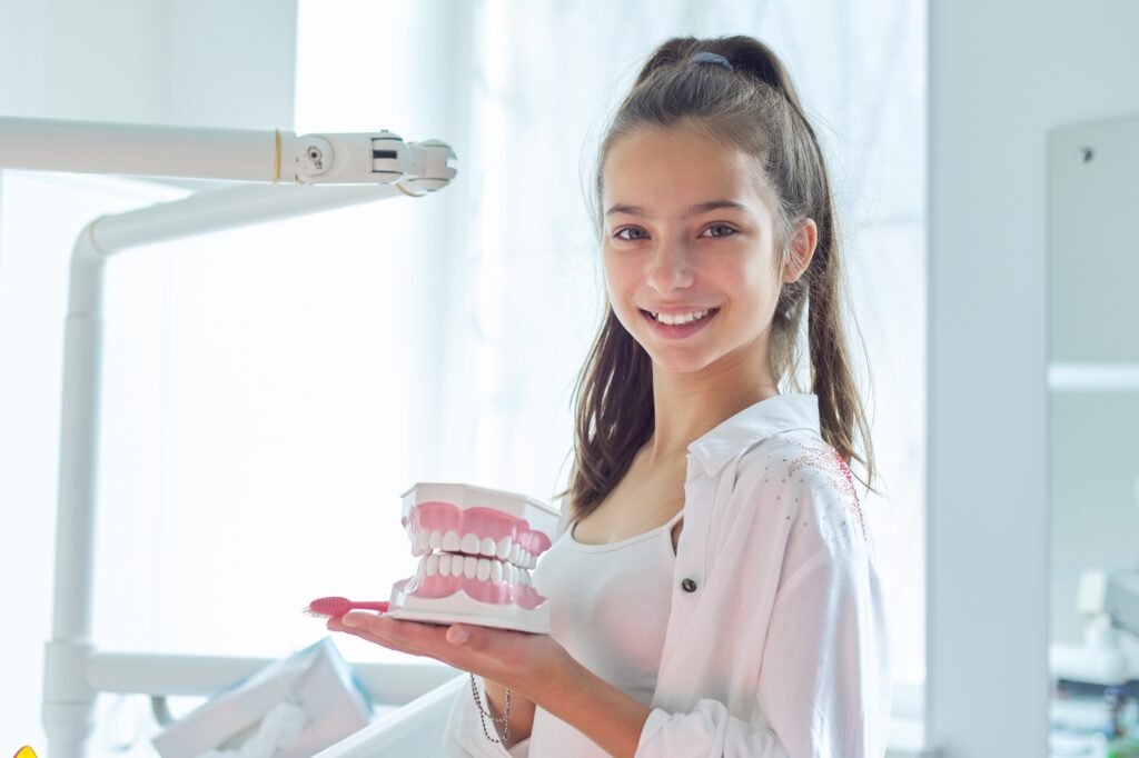 Teen girl at orthodontist learning about aligners. 