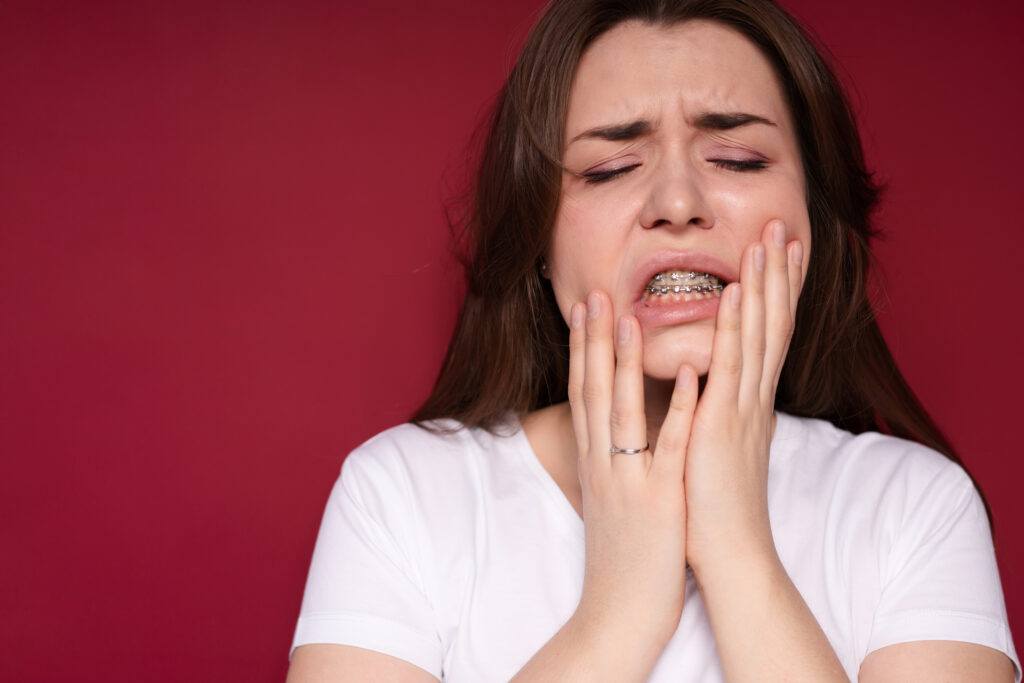 Young woman in pain from braces.