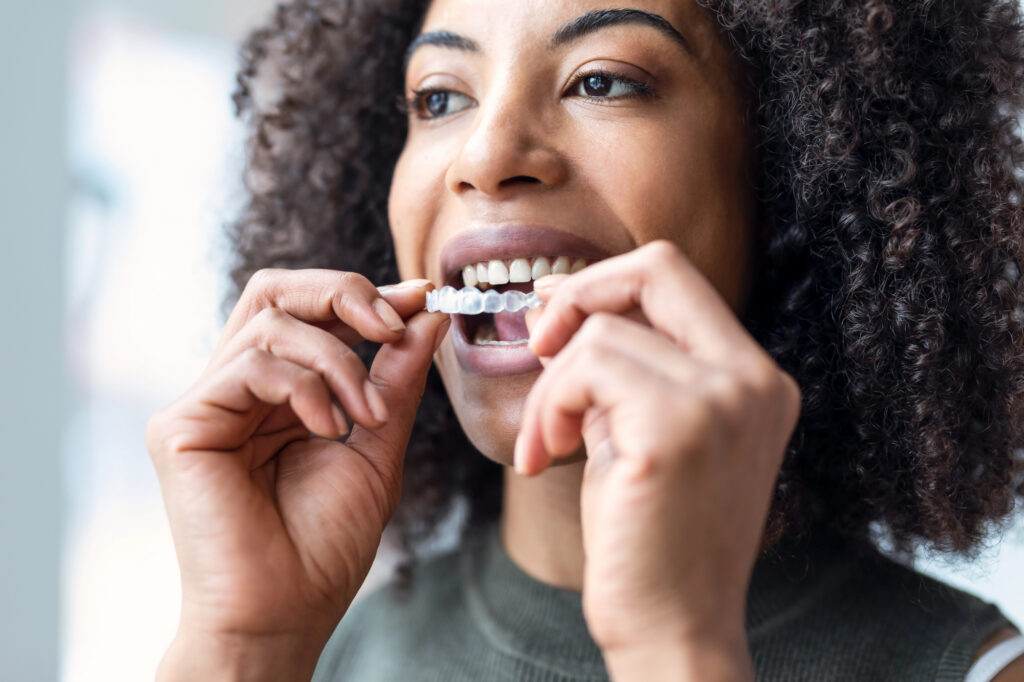 Young woman inserting clear aligners. 