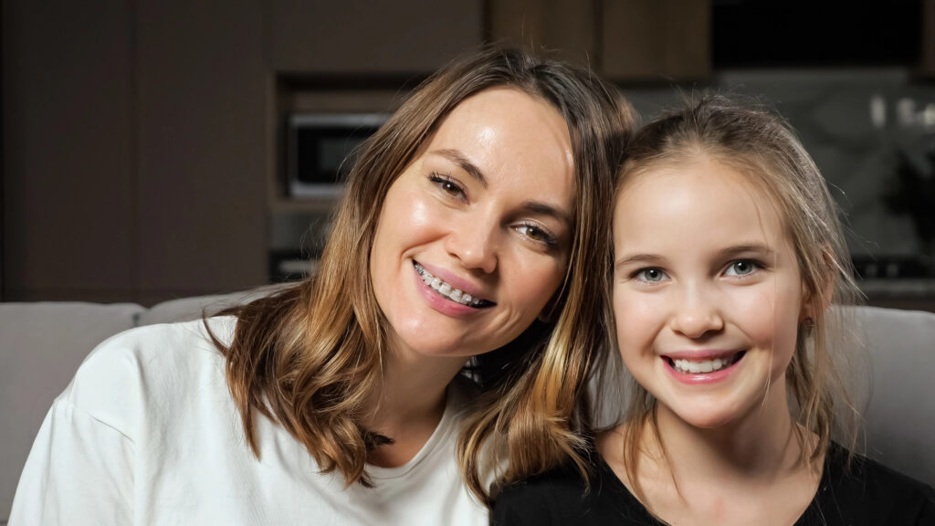Mother with braces and daughter with clear aligners.